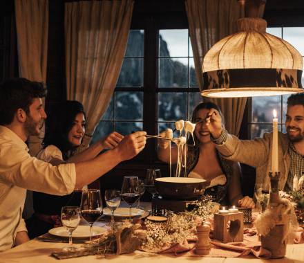 Hotel mit Berghütte im Allgäu - Freunde essen Fondue in gemütlichen Ambiente