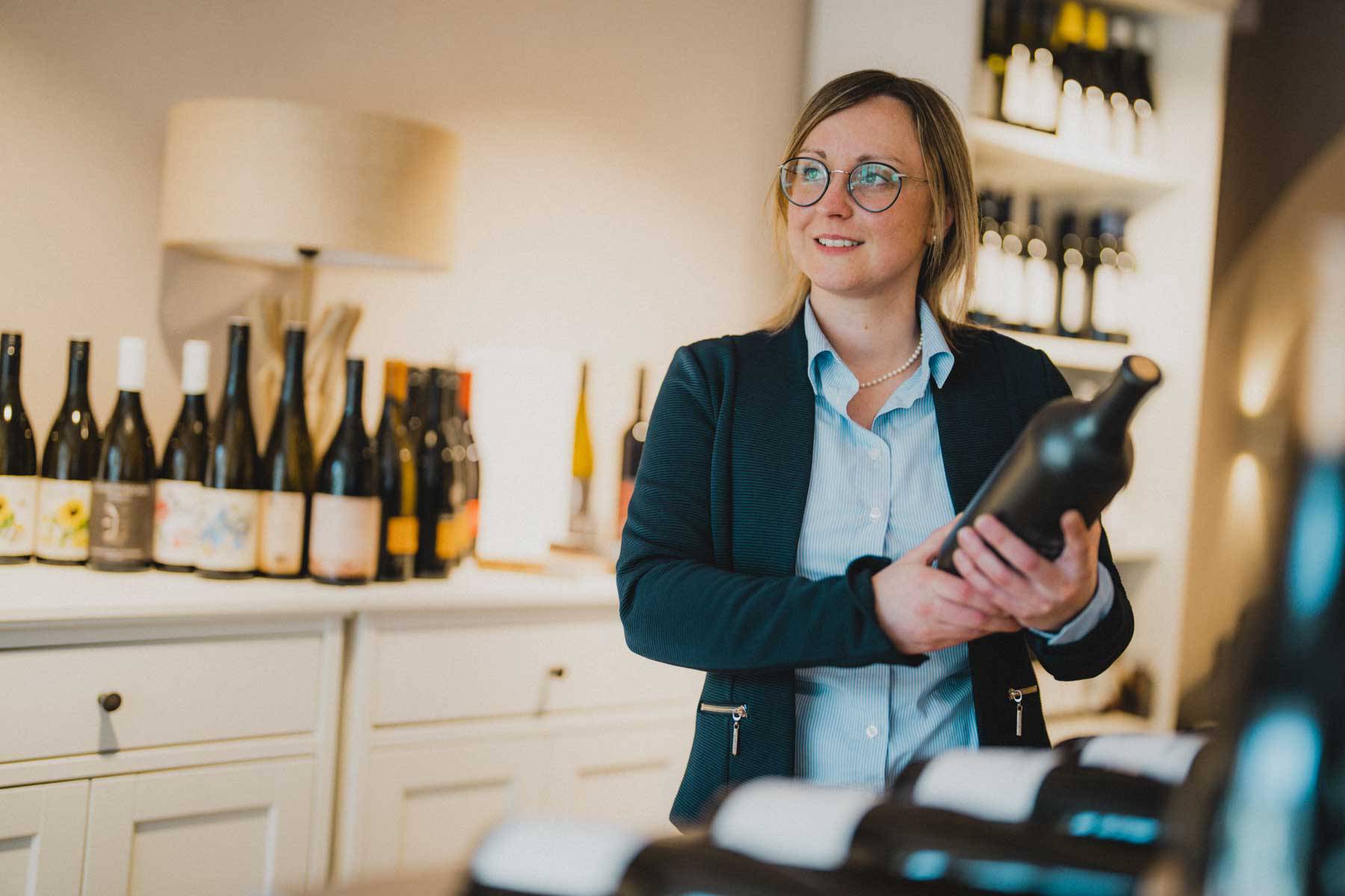 Frau Caroline Zuber mit Weinflasche im Weinhotel