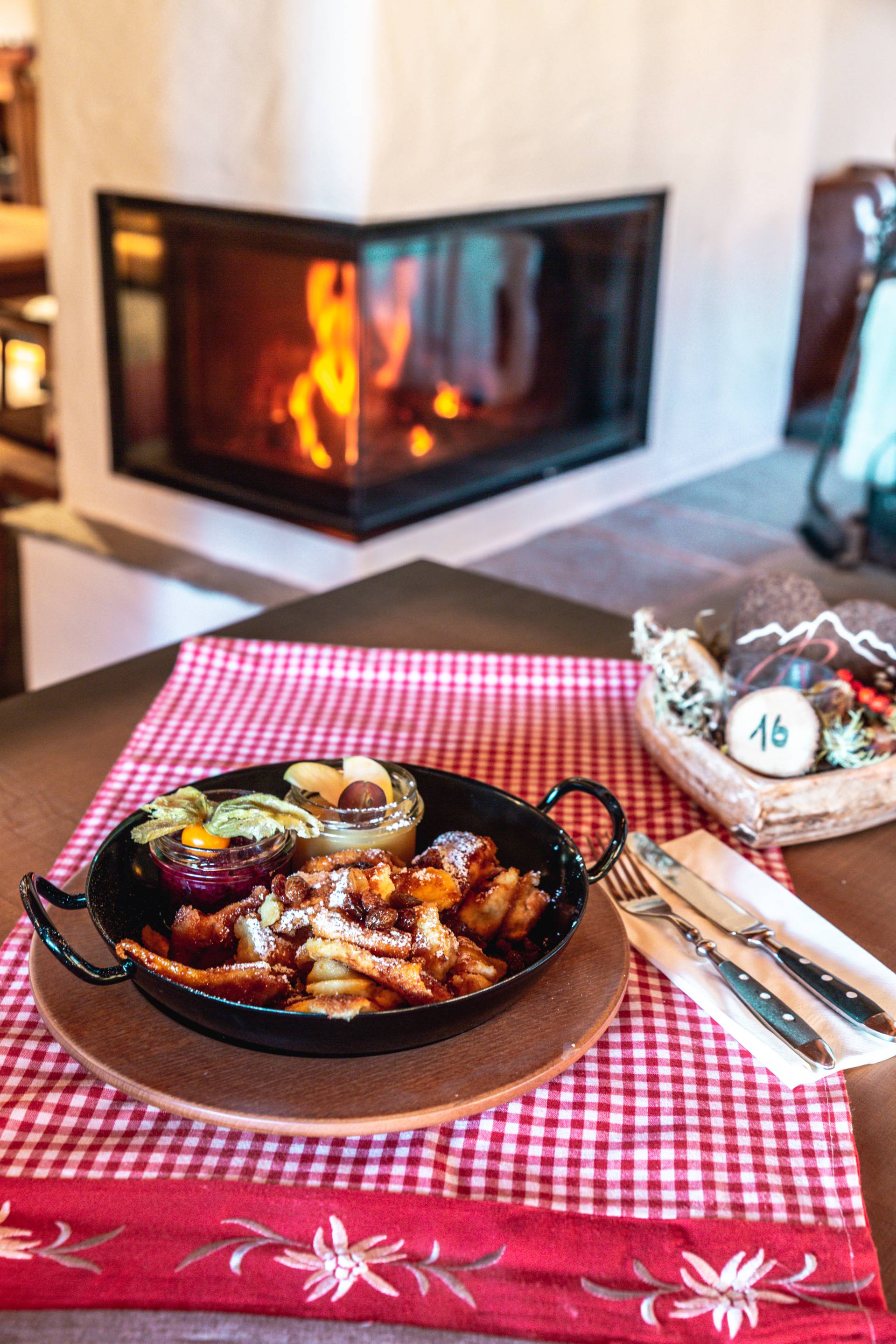 Kaiserschmarrn in Gusseisenpfanne auf Tisch vor Karmin