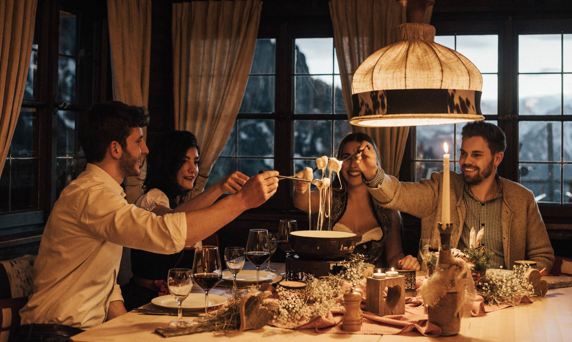 Hotel mit Berghütte im Allgäu - Freunde essen Fondue in gemütlichen Ambiente