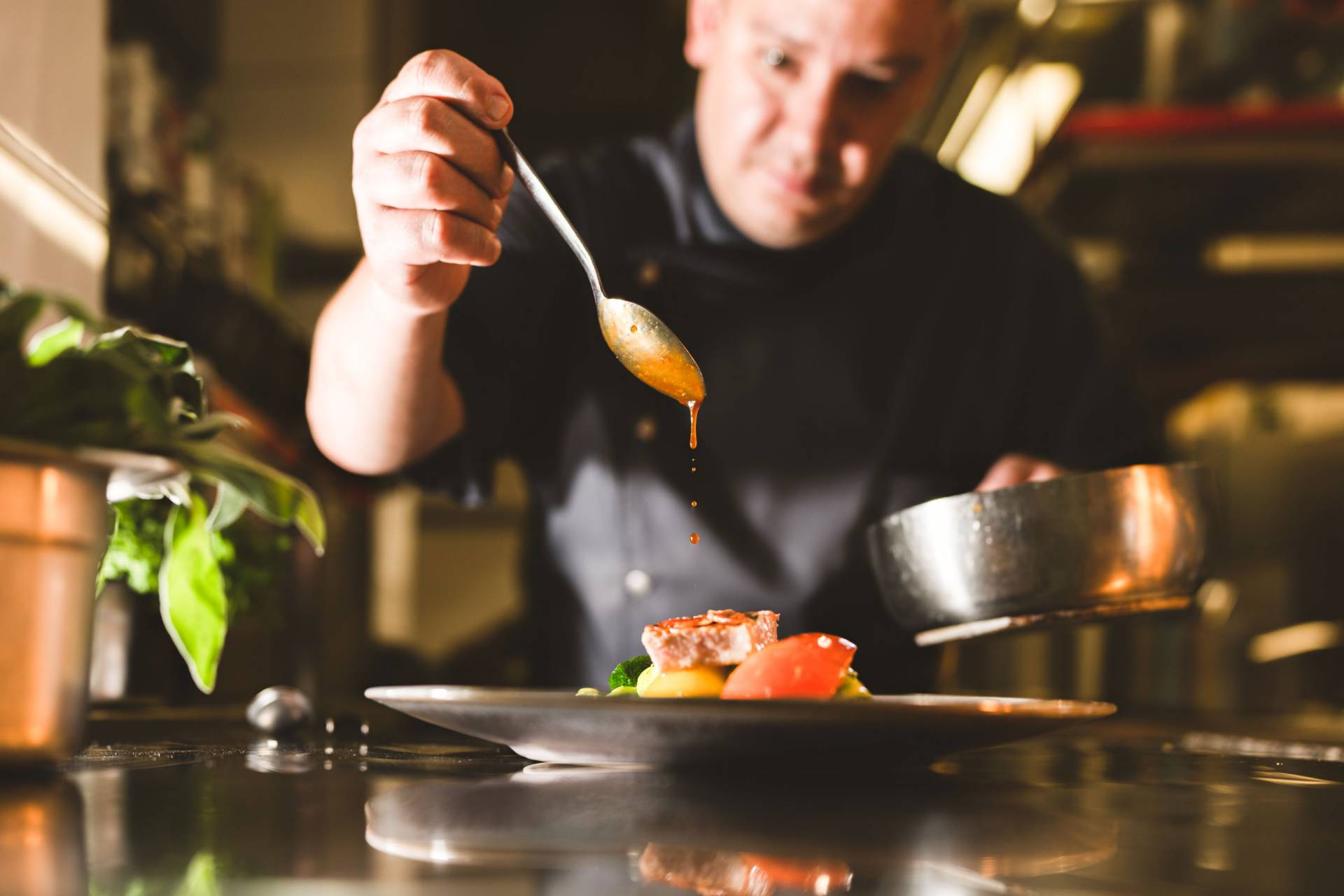 Koch verfeinert Gericht mit einer Soße
