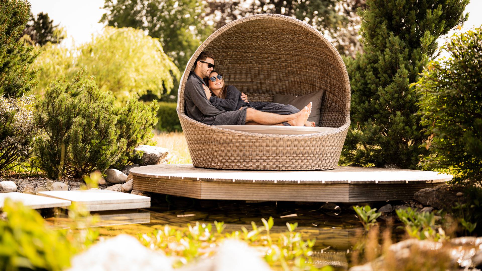 Wellnessurlaub im Allgäu - Paar kuschelt in Strandmuschel