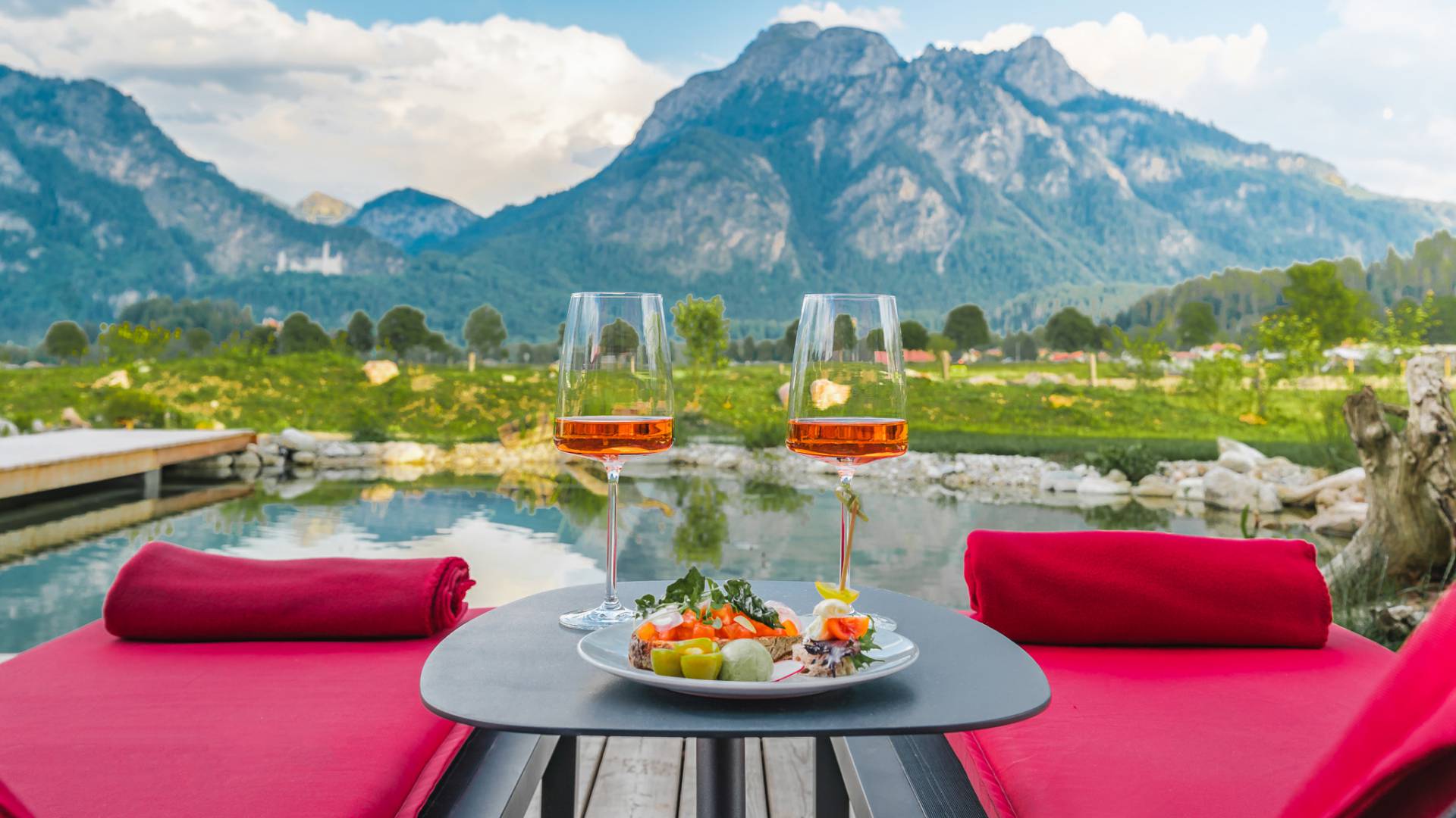 Außenliegen mit Tisch und Weingläsern auf Beistelltisch und Panoramablick auf die Berge