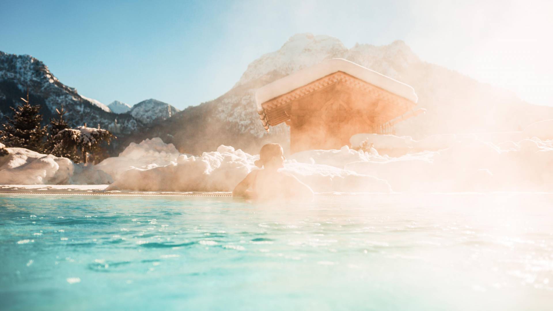Hotel mit beheiztem Pool im Winter: Frau ist entpannt im Aussenpool