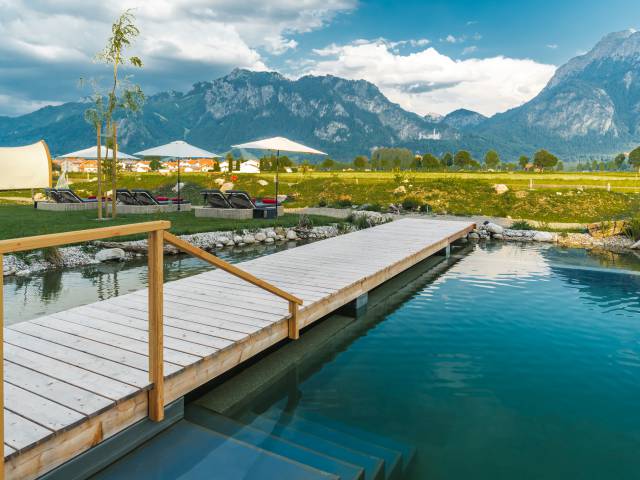 Naturpool mit Blick auf die Berge und Schloss Neuschwanstein