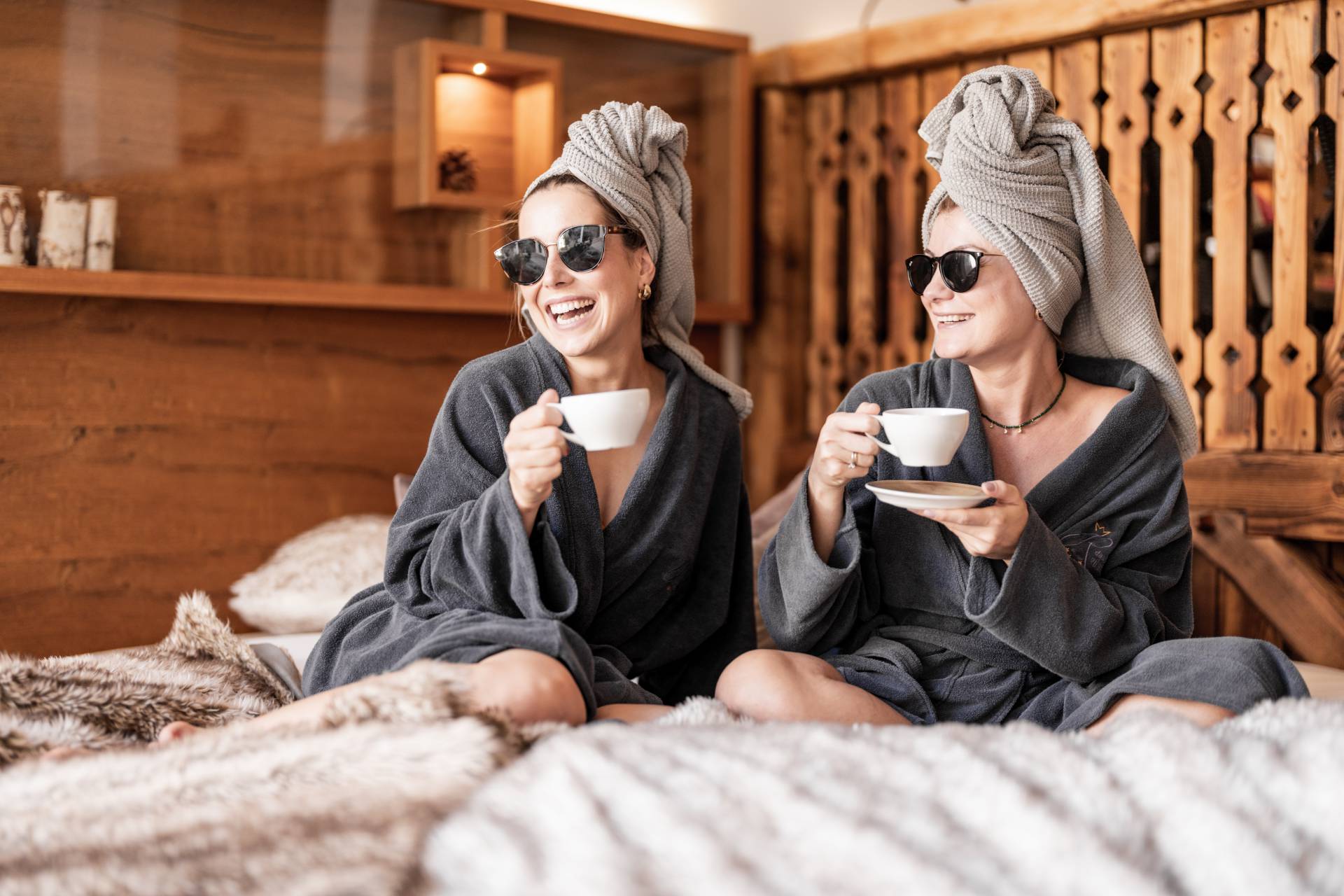 Ayurveda Retreat - Freundinnen in Bademantel entspannen bei einer Tasse Kaffee