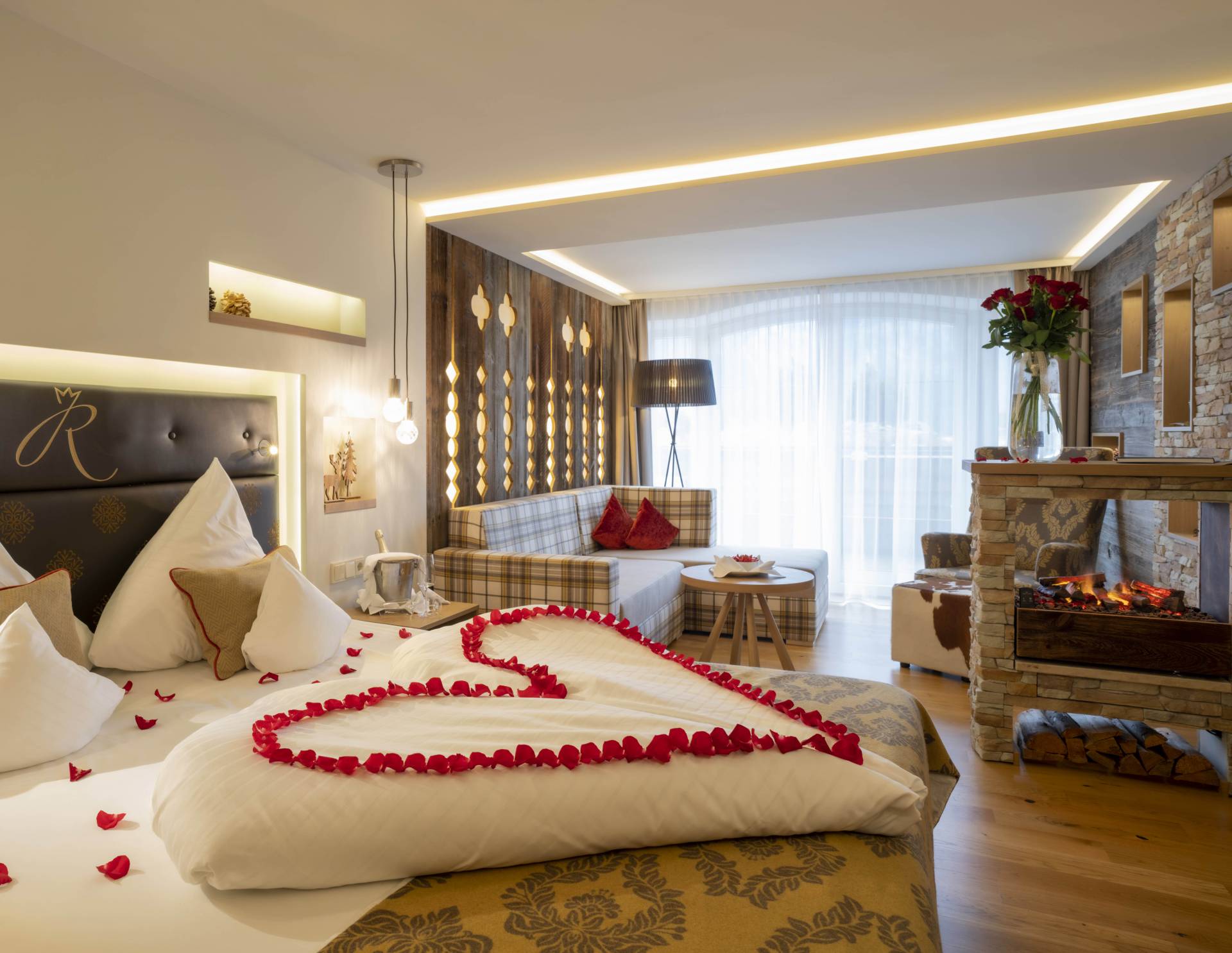 Rosenblätter in Herzform auf Hotelbett