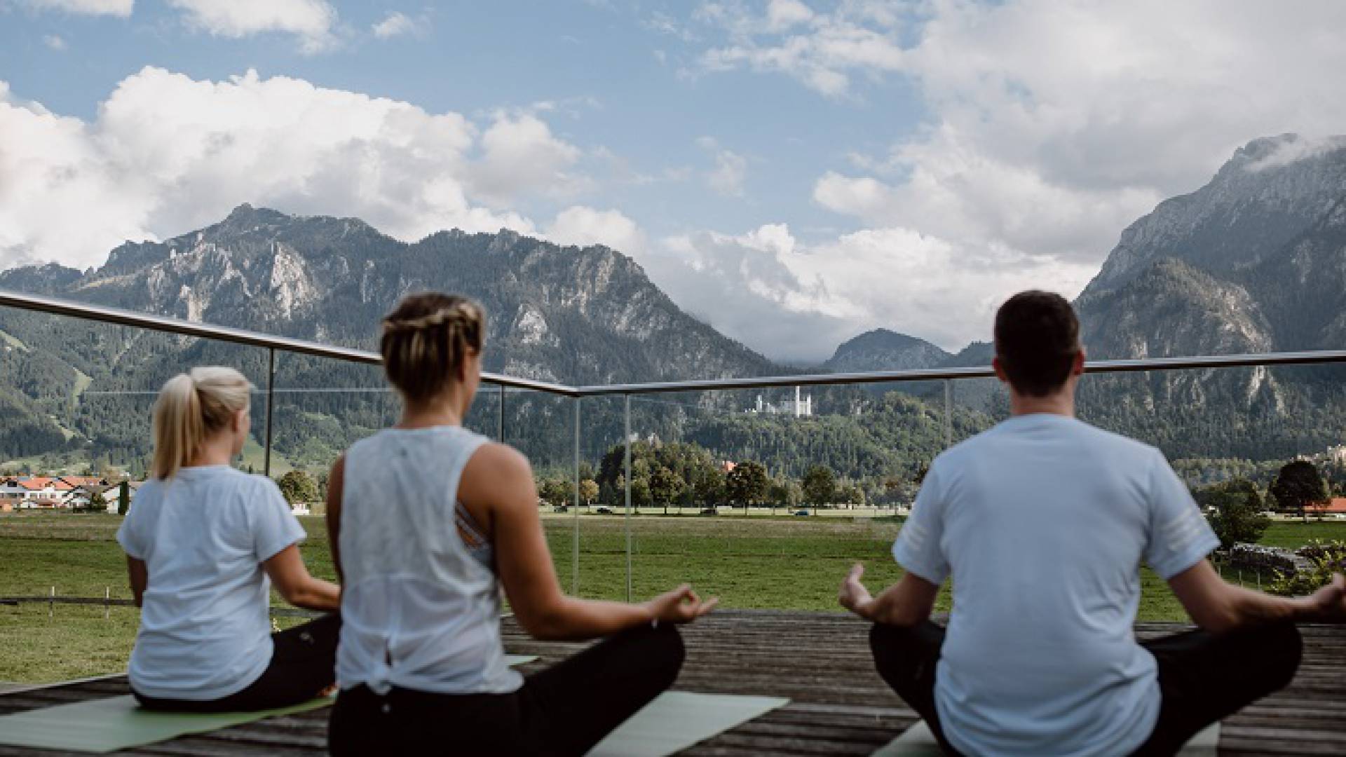 Yoga mit Blick aufs Schloss - Personen machen Yoga im Feiern