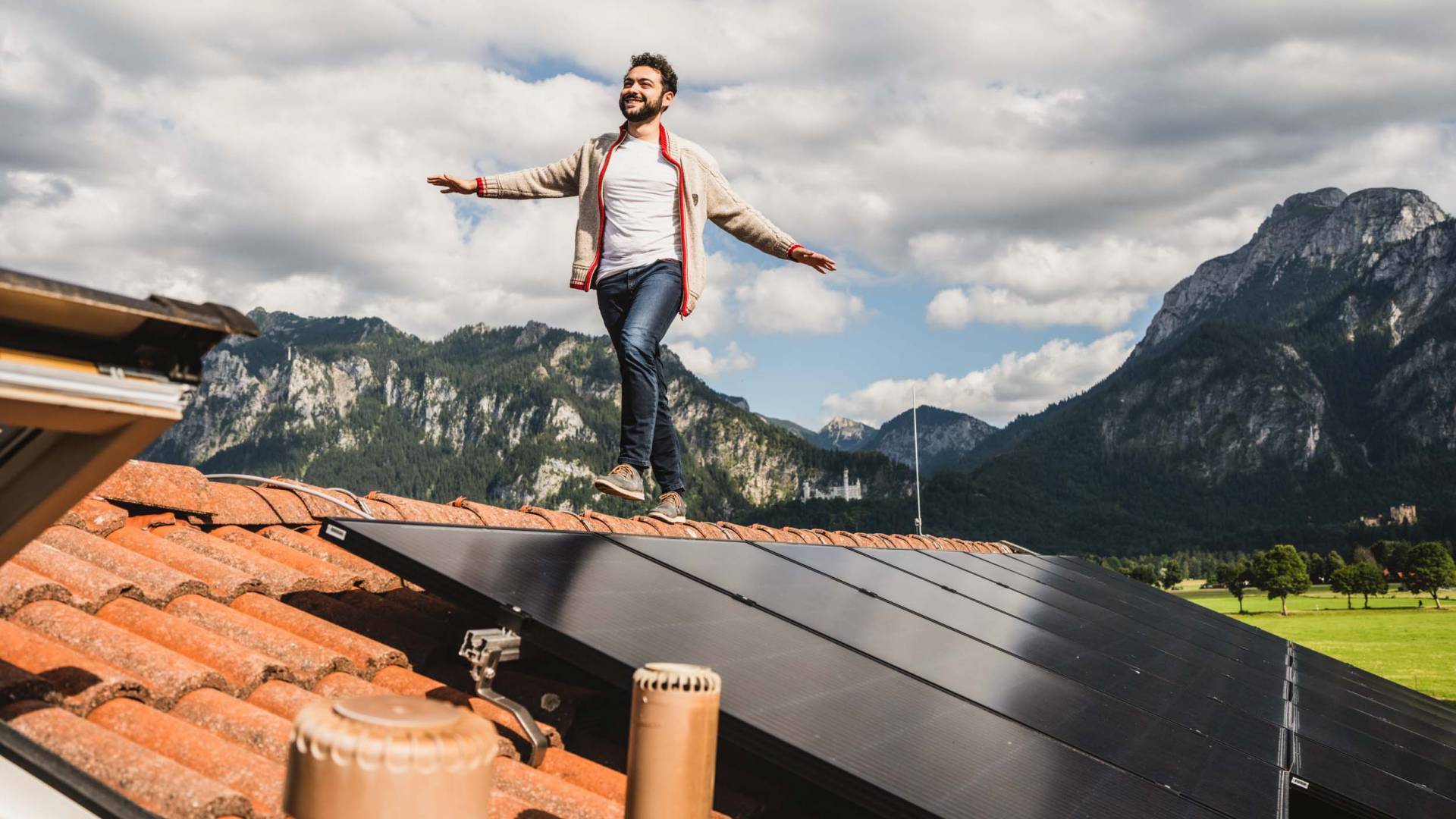 Umweltfreundliches Hotel das Rübezahl im Allgäu - Mann balanciert auf Hausdach zwischen Solarzellen