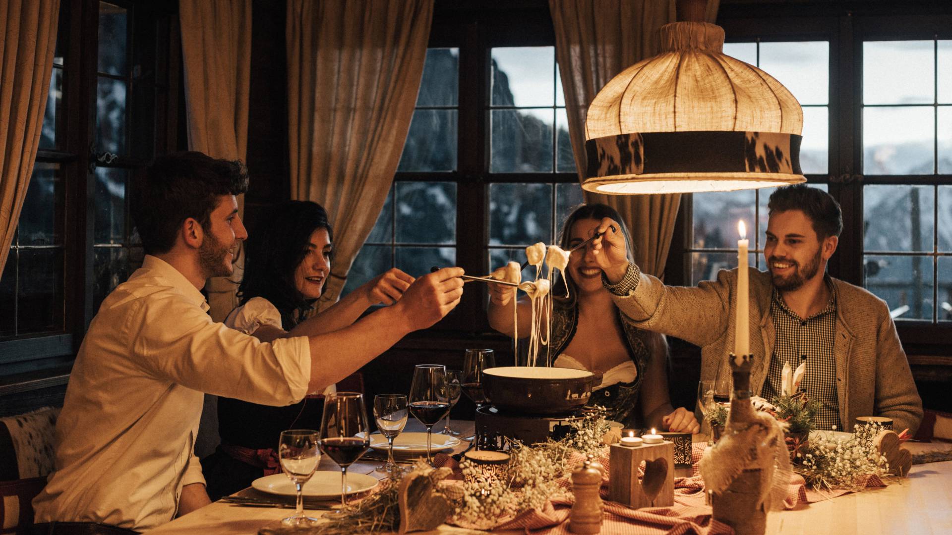 Hotel mit Berghütte im Allgäu - Freunde essen Fondue in gemütlichen Ambiente