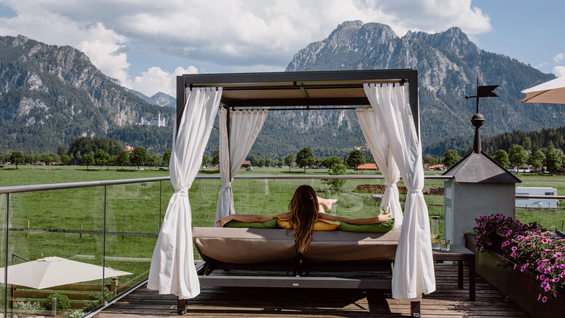 Frau in Dailybett auf dem Panoramadeck mit Blick aufs Schloss