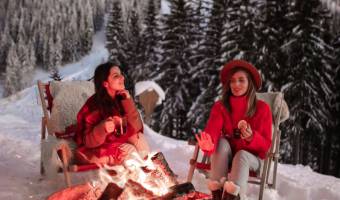 Frauen sitzen am Lagerfeuer in den Bergen
