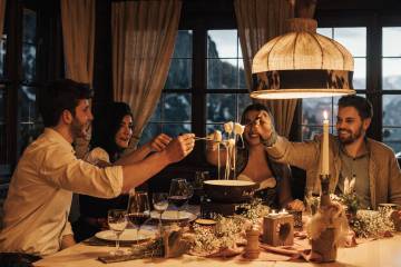 Hotel mit Berghütte im Allgäu - Freunde essen Fondue in gemütlichen Ambiente