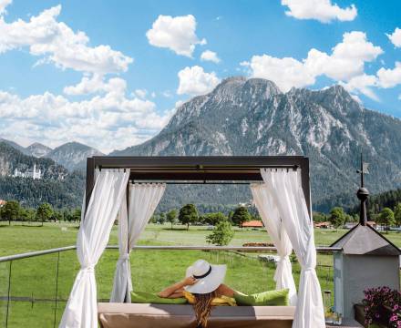 4 Sterne Wellnesshotel in Bayern - Frau mit Sonnenhut liegt auf Dailybett