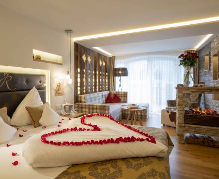 Rosenblätter in Herzform auf Hotelbett