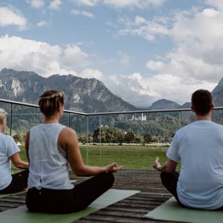 Yoga mit Blick aufs Schloss - Personen machen Yoga im Feiern