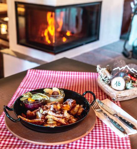 Kaiserschmarrn in Gusseisenpfanne auf Tisch vor Karmin