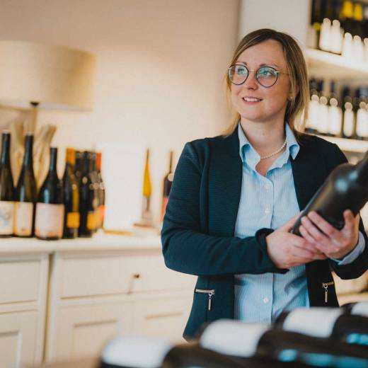 Frau Caroline Zuber mit Weinflasche im Weinhotel