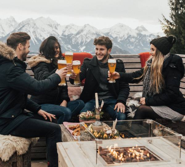 Personen bei Jause auf der Rohrkopfhütte am Tegelberg