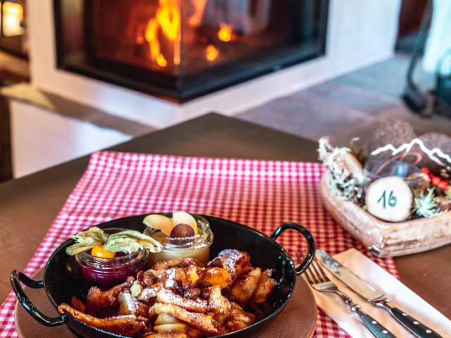 Kaiserschmarrn in Gusseisenpfanne auf Tisch vor Karmin